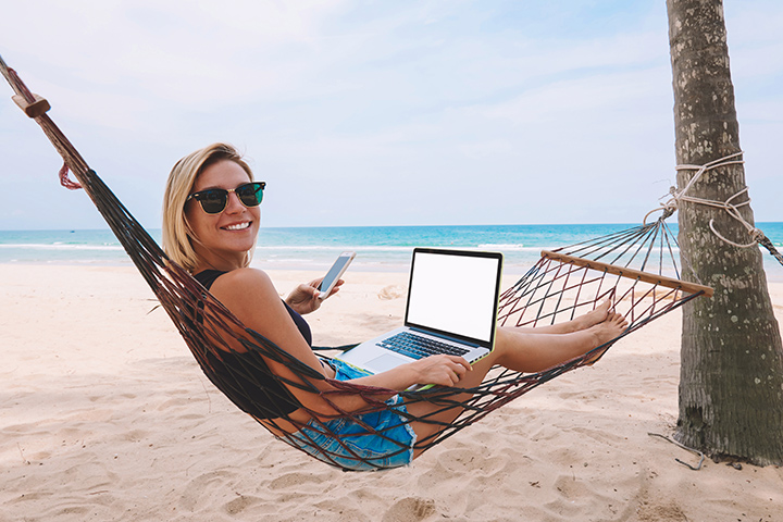 Woman working on the beach with computer